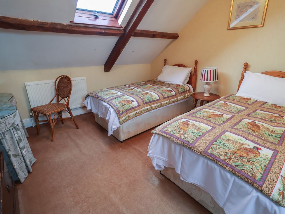 A bedroom with two beds and a lamp at Winston Lodge in Beccles