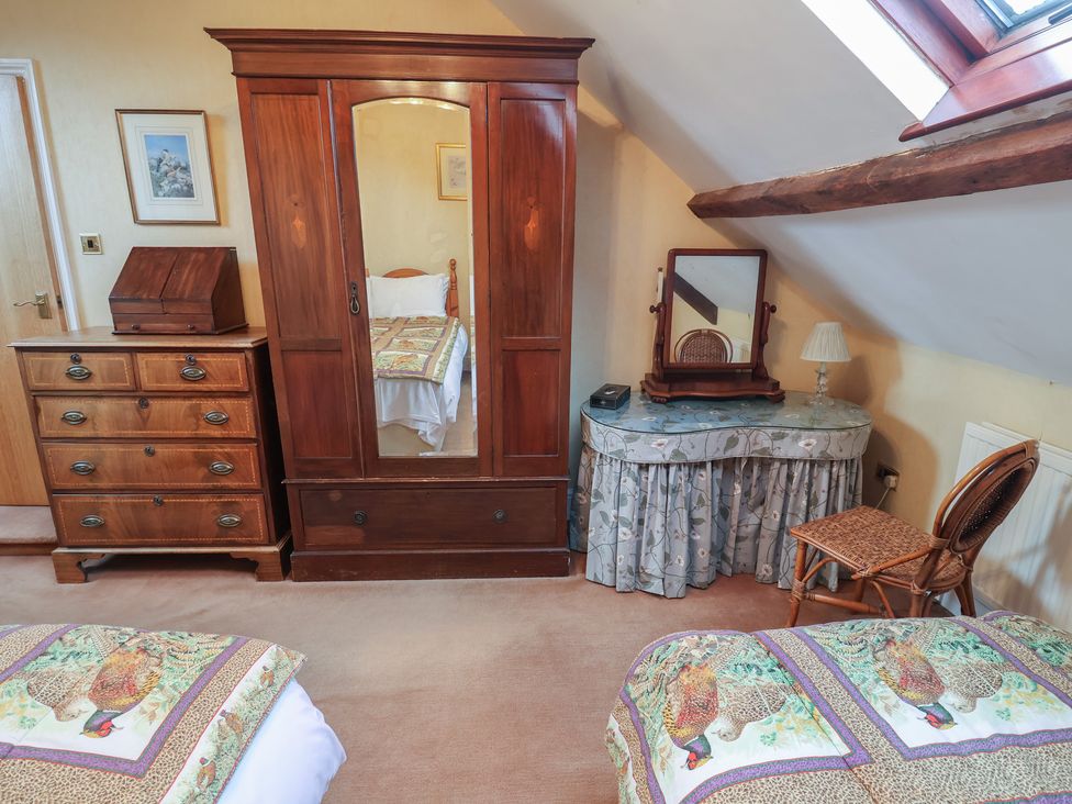 A bedroom with a wardrobe and chest of drawers at Winston Lodge in Beccles