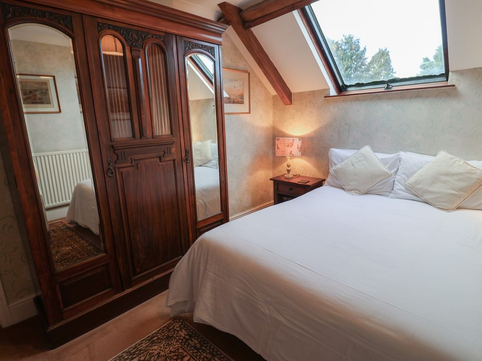 A bedroom with a bed and wardrobe at Winston Lodge in Beccles