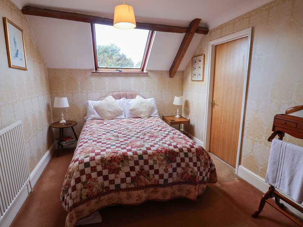A bedroom with a bed and a table at Winston Lodge in Beccles