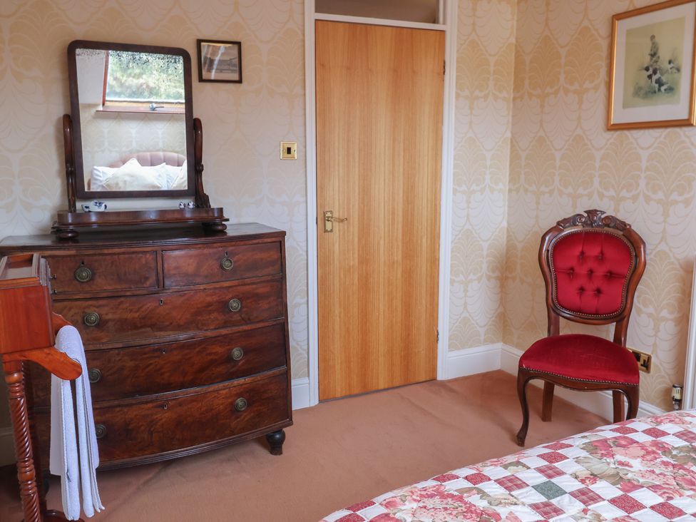 A bedroom with a dresser and a mirror at Winston Lodge in Beccles