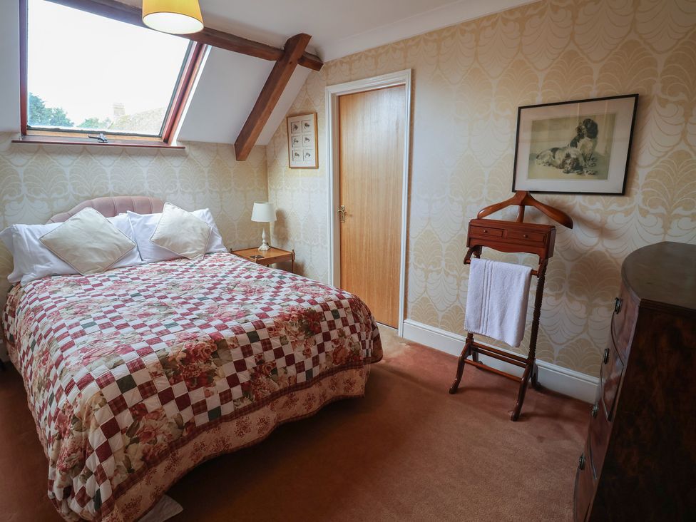 A bedroom with a bed and a towel rack at Winston Lodge in Beccles
