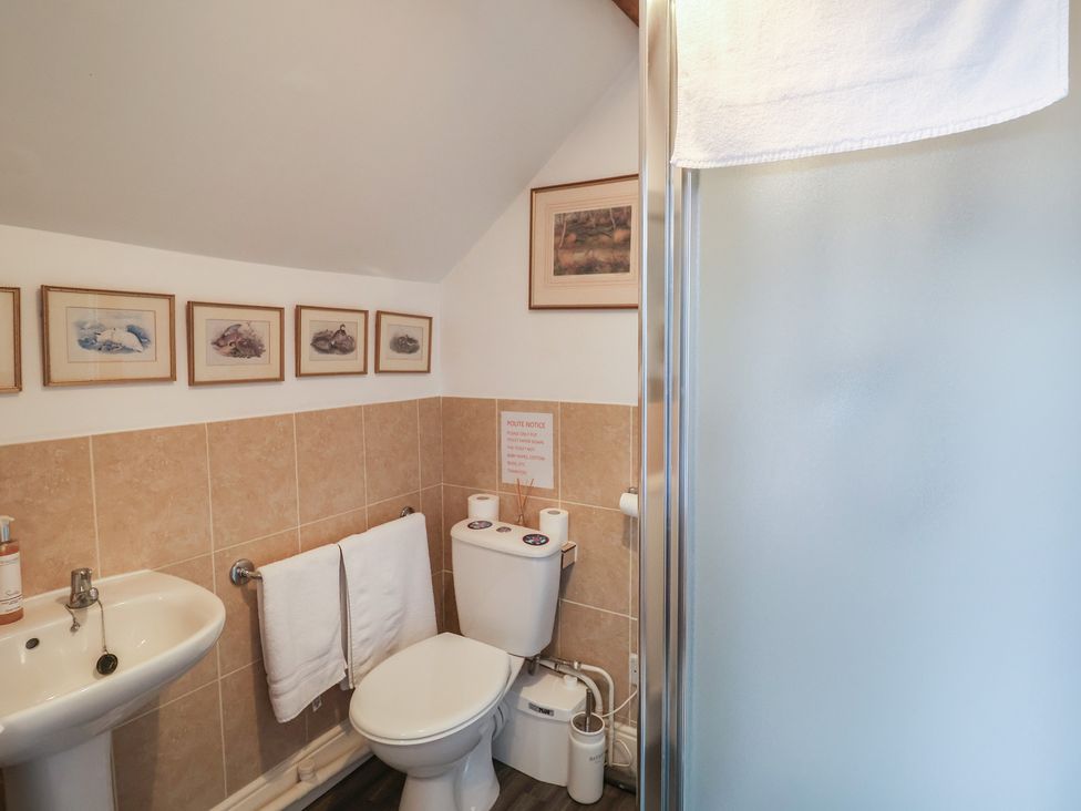 A bathroom with a sink, toilet, and shower at Winston Lodge in Beccles