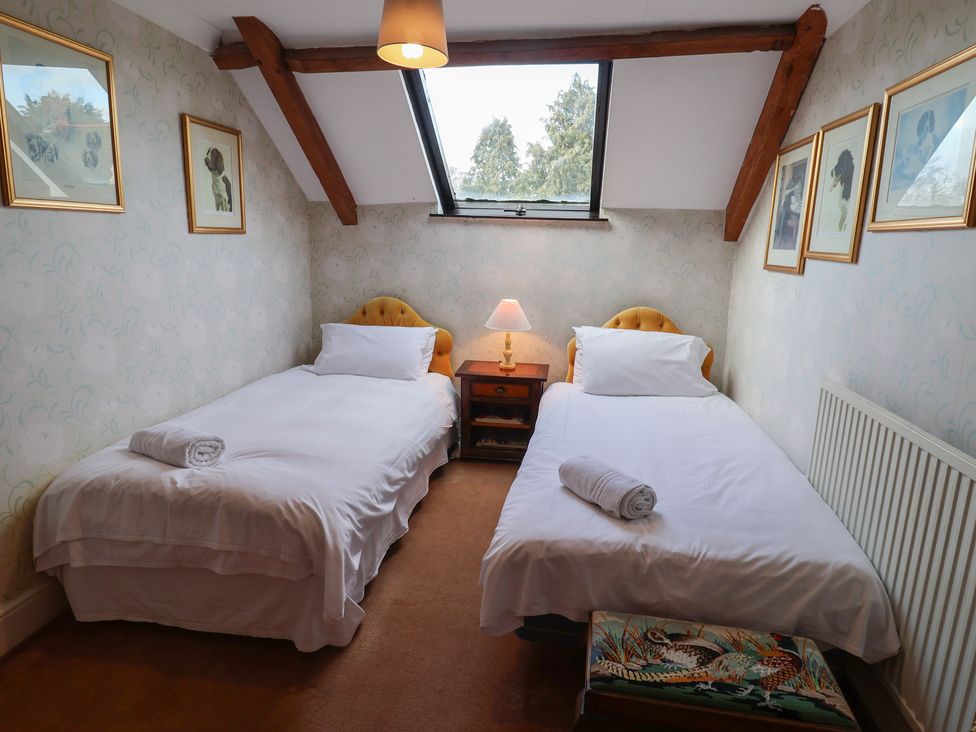 A bedroom with two single beds and a nightstand at Winston Lodge in Beccles