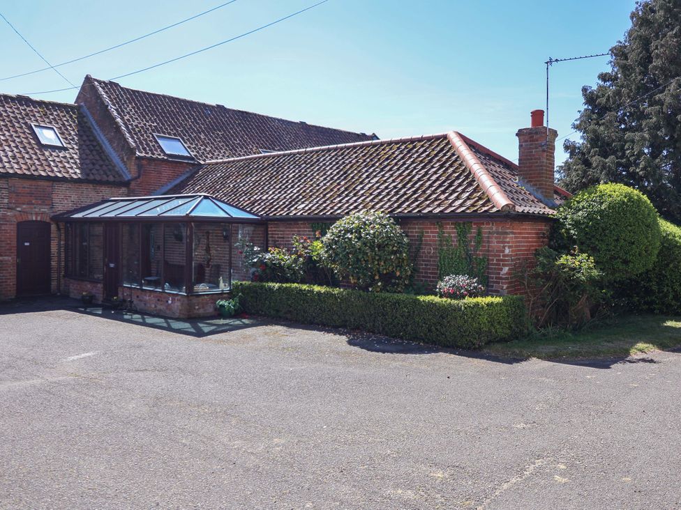 A house with a conservatory and garden at Winston Lodge in Beccles