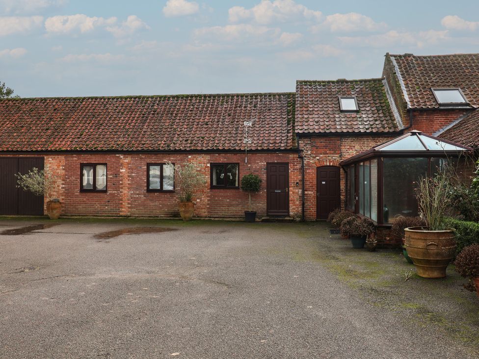 An outdoor view of a brick building with potted plants at The Gun Room in Beccles