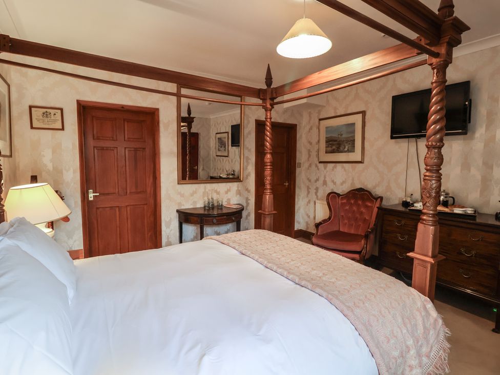 A bedroom with a four-poster bed and furniture at The Gun Room in Beccles