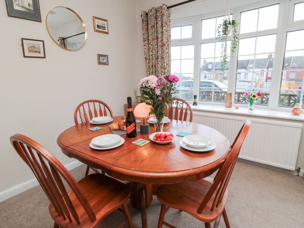 A dining room with a table set for four at Cattersty Cottage