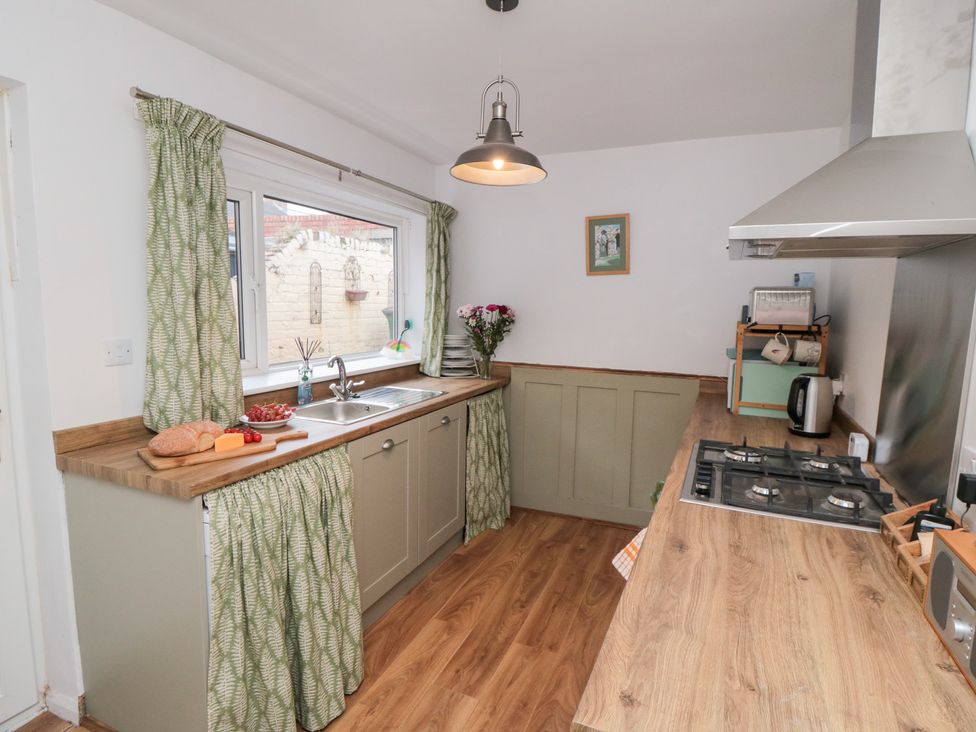 A kitchen with a sink and stove at Cattersty Cottage