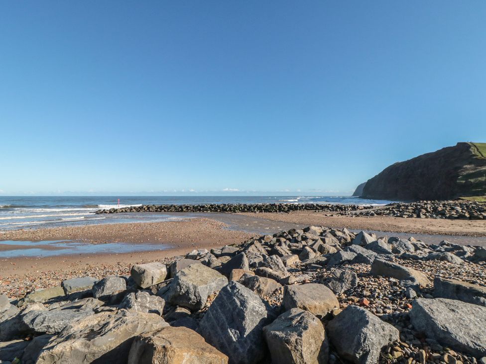A beach with rocks and ocean waves at Cattersty Cottage in Carlin How