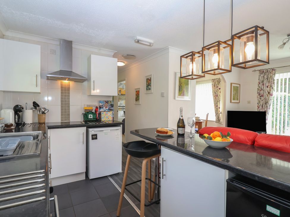 A kitchen with a bar stool and fruit bowl at Westview in Liskeard