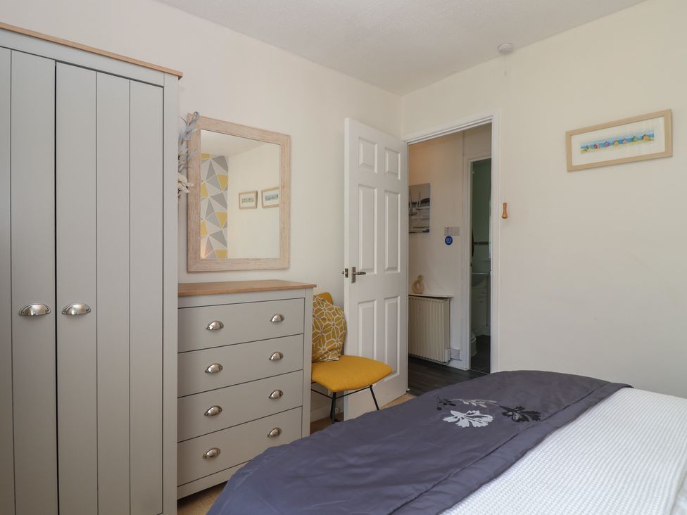 A bedroom with a wardrobe, dresser and mirror at Westview in Liskeard