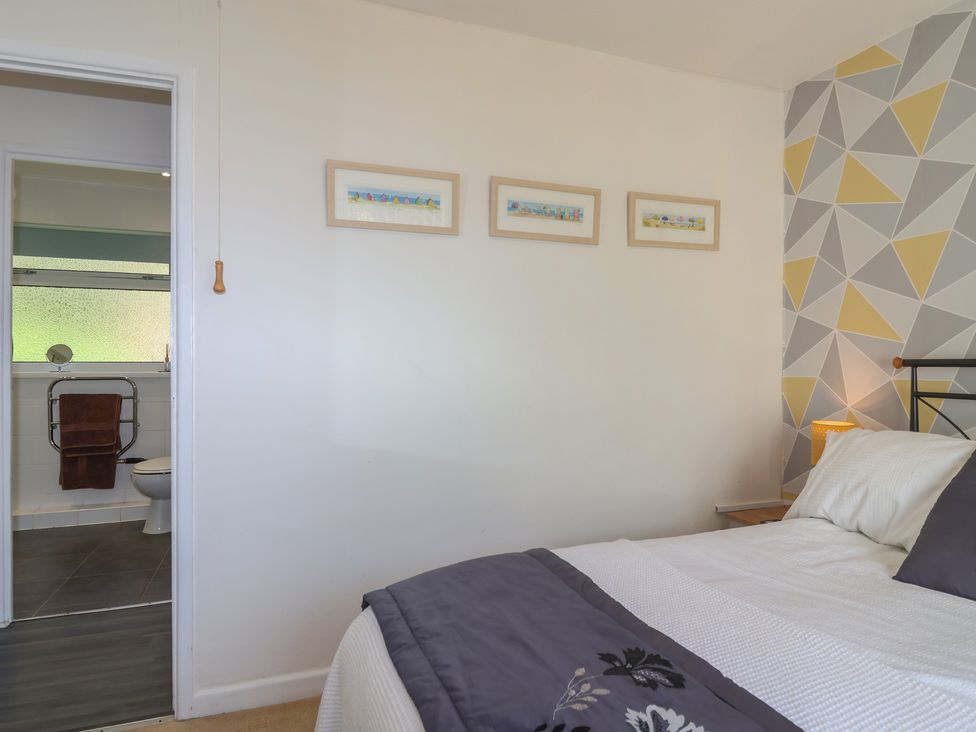 A bedroom with a bed and bathroom access at Westview in Liskeard