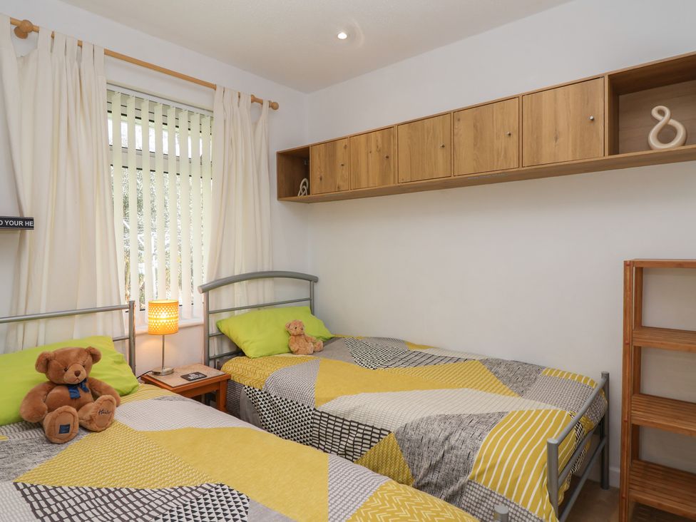A bedroom with two beds and a shelf at Westview in Liskeard
