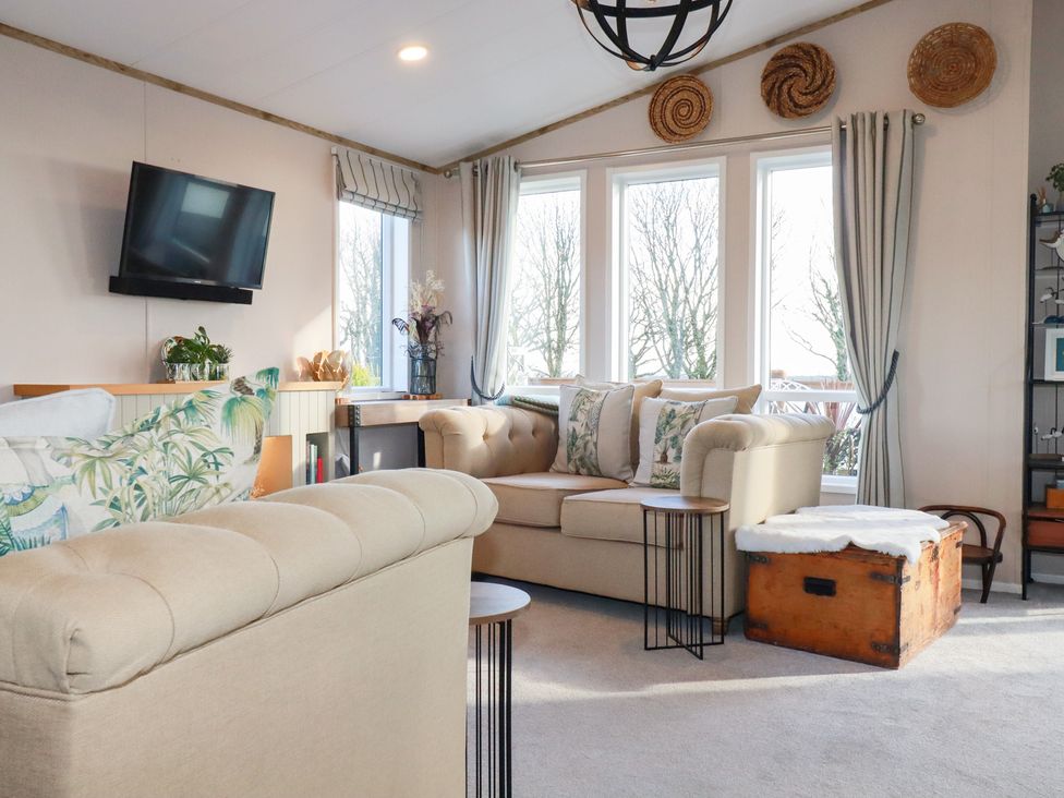 A living room with a television and windows at FW4 (Fairways 4)