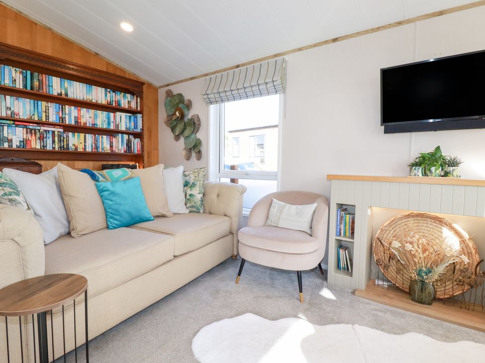 A living room with a sofa and bookshelf at FW4 (Fairways 4)