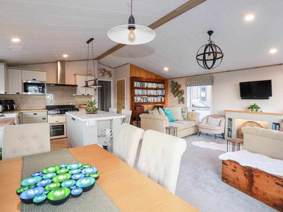 A living room and kitchen area with dining table and sofa at FW4 (Fairways 4)