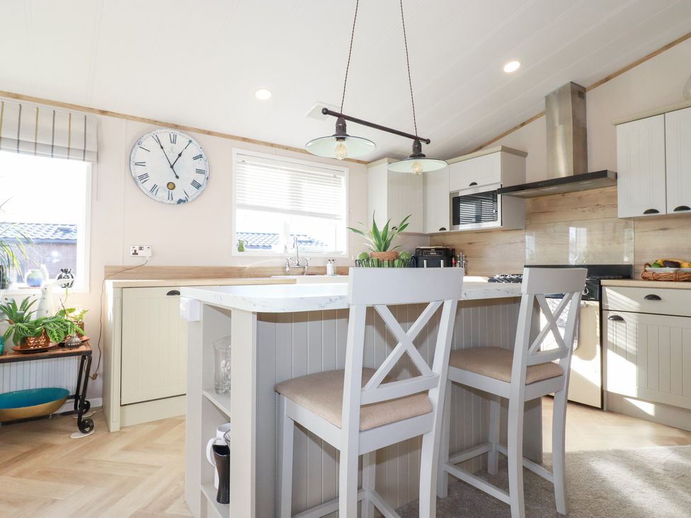 A kitchen with an island and stools at FW4 (Fairways 4)