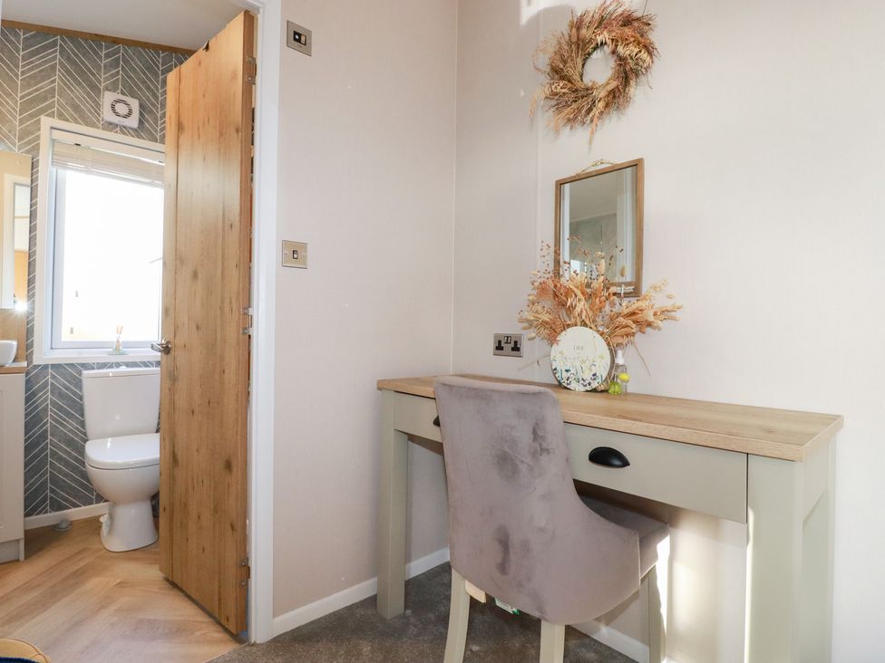 A bathroom with a desk and chair at FW4 (Fairways 4)