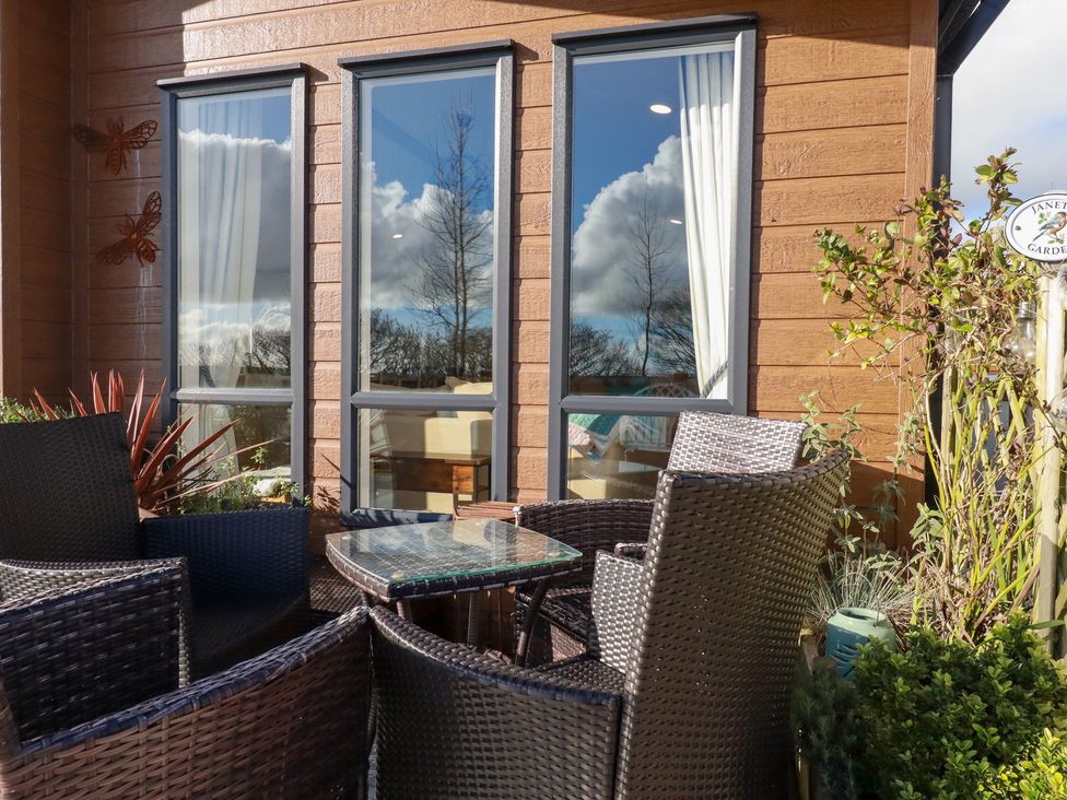 An outdoor seating area with a table and chairs near windows at FW4 (Fairways 4)