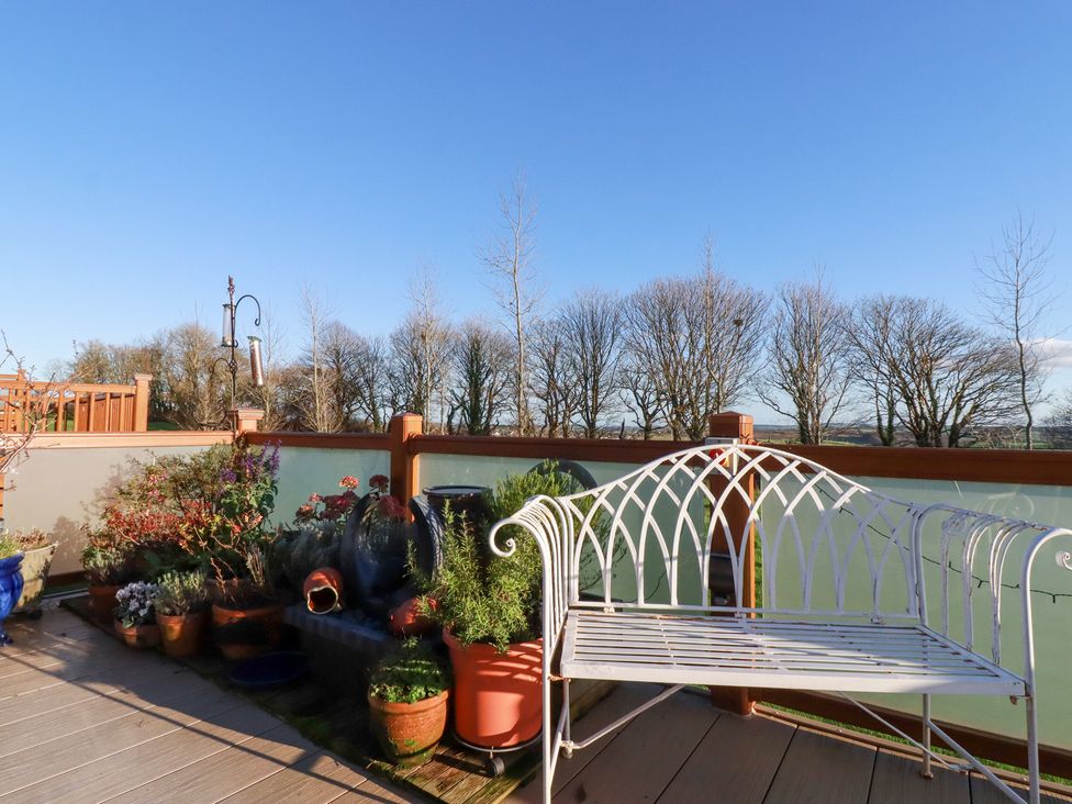 A garden area with a bench and various planters at FW4 (Fairways 4) Doublebois near Dobwalls