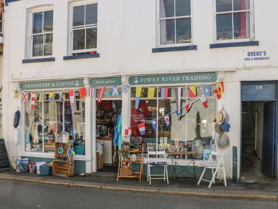 A storefront displaying goods and seating at Fowey River Trading in Doublebois near Dobwalls