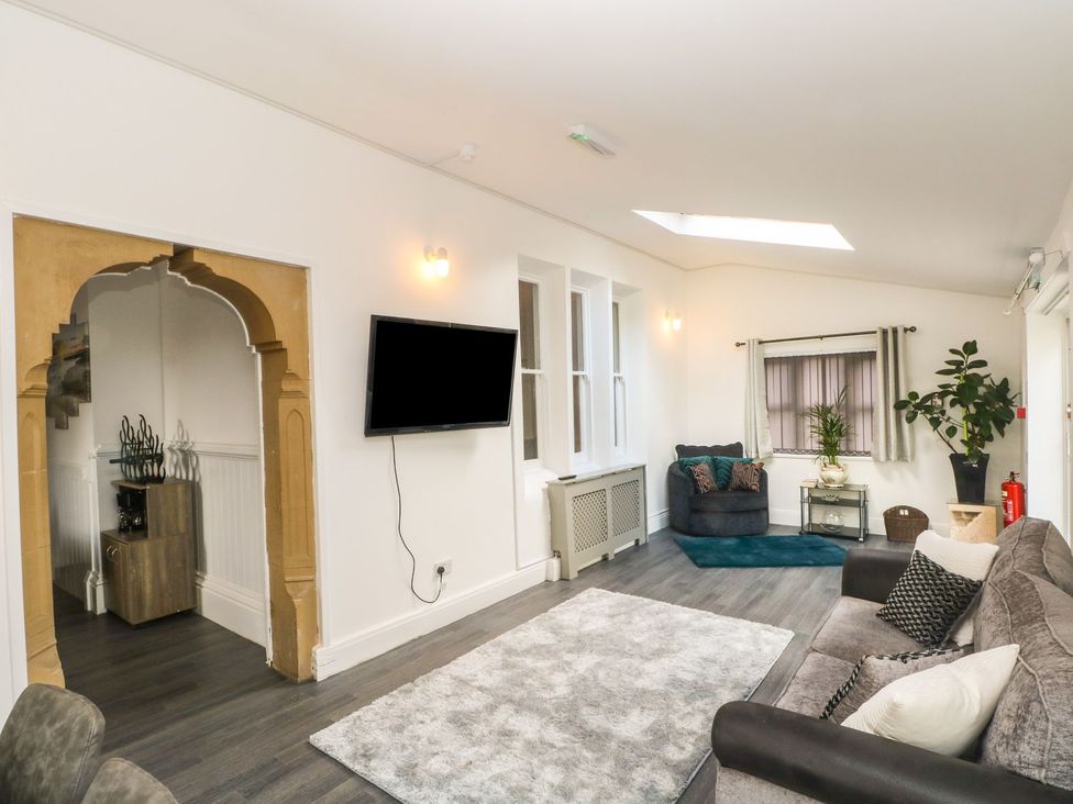 A living room with a television and a plant at Beechwood House in Hadfield