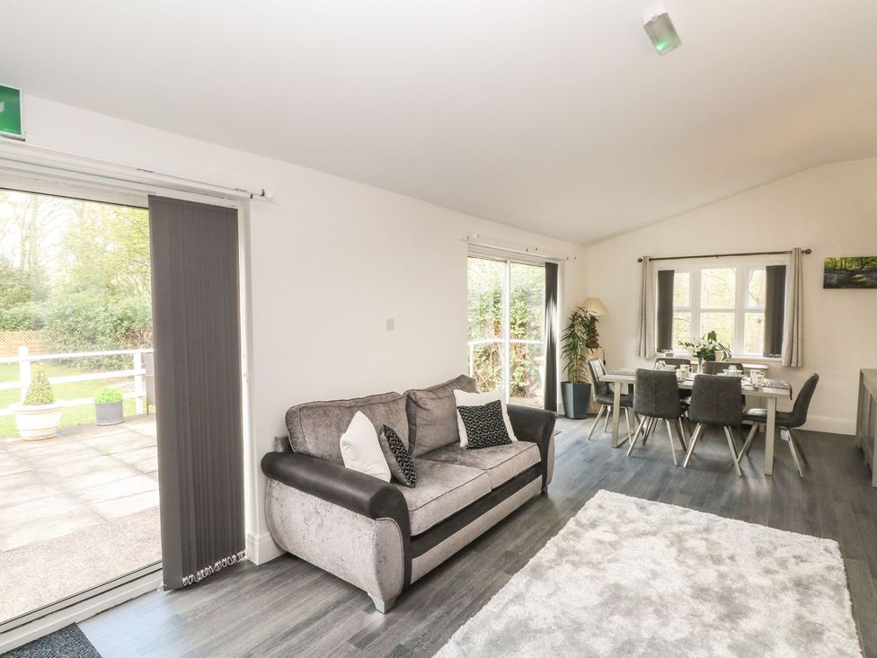 A living room with a sofa and dining area at Beechwood House in Hadfield