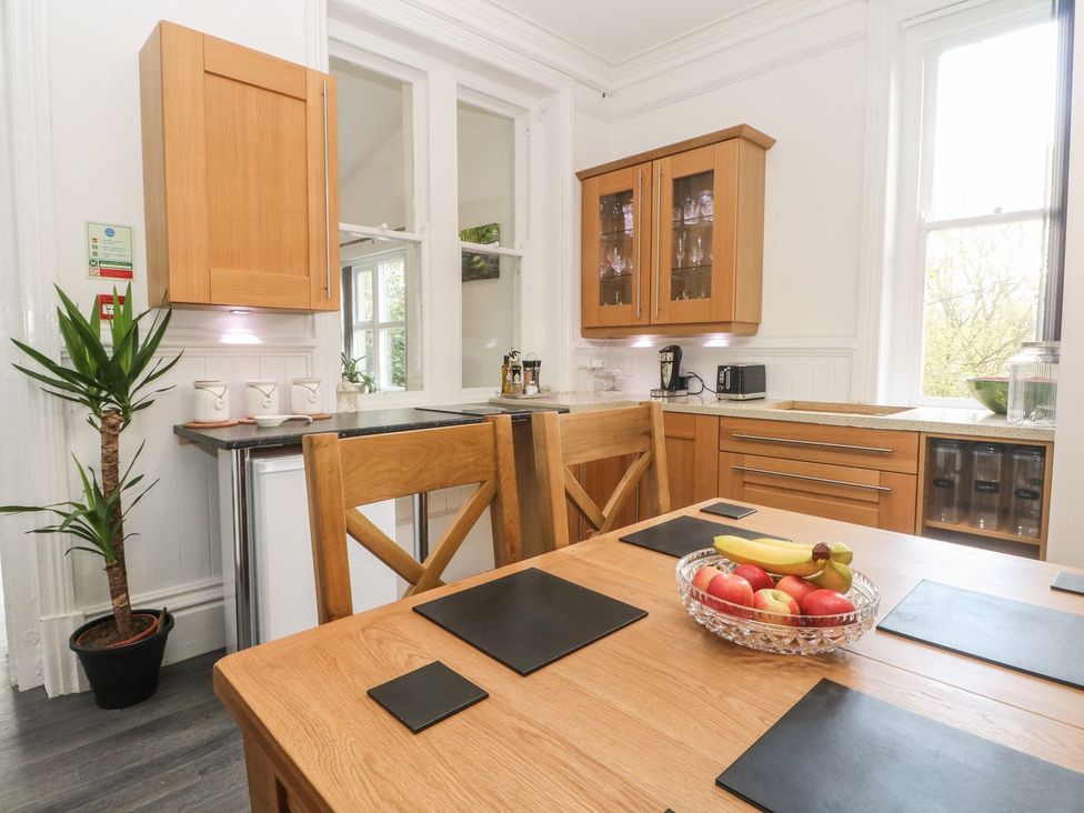 A kitchen with wooden furniture and appliances at Beechwood House in Hadfield