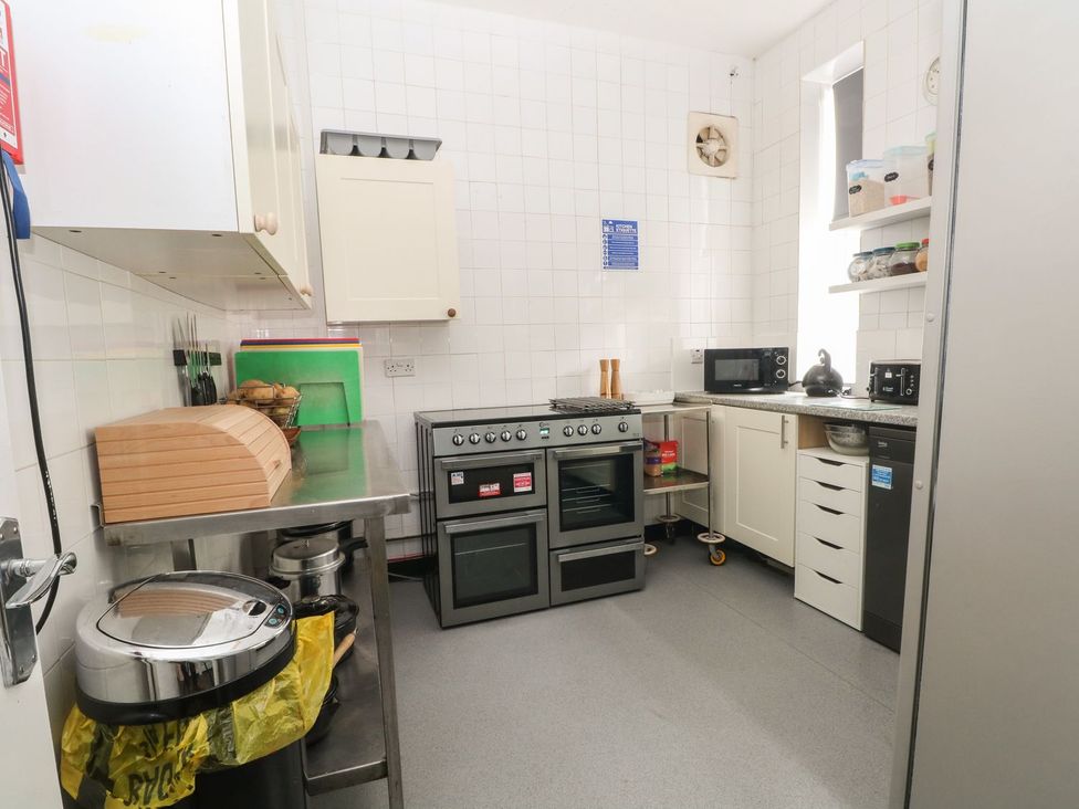 A kitchen with stove, sink, and appliances at Beechwood House Hadfield