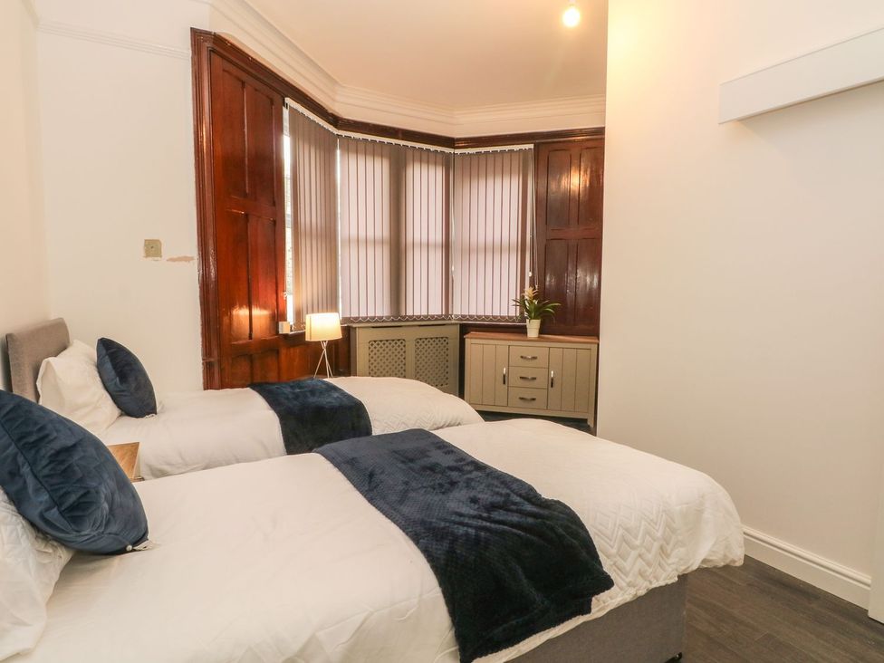 A bedroom with two beds and a lamp at Beechwood House in Hadfield
