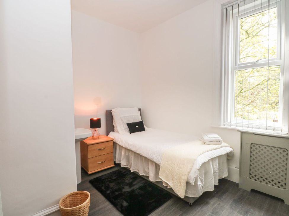 A bedroom with a bed and nightstand at Beechwood House in Hadfield
