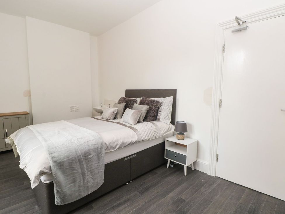 A bedroom with a bed and bedside table at Beechwood House in Hadfield