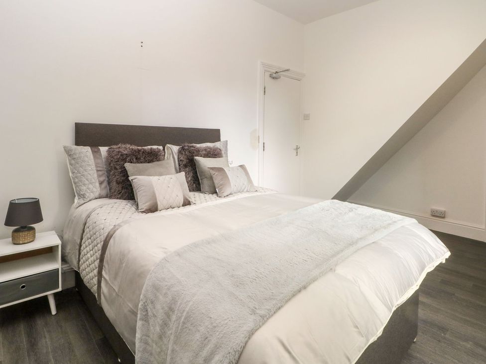 A bedroom with a bed and nightstand at Beechwood House in Hadfield