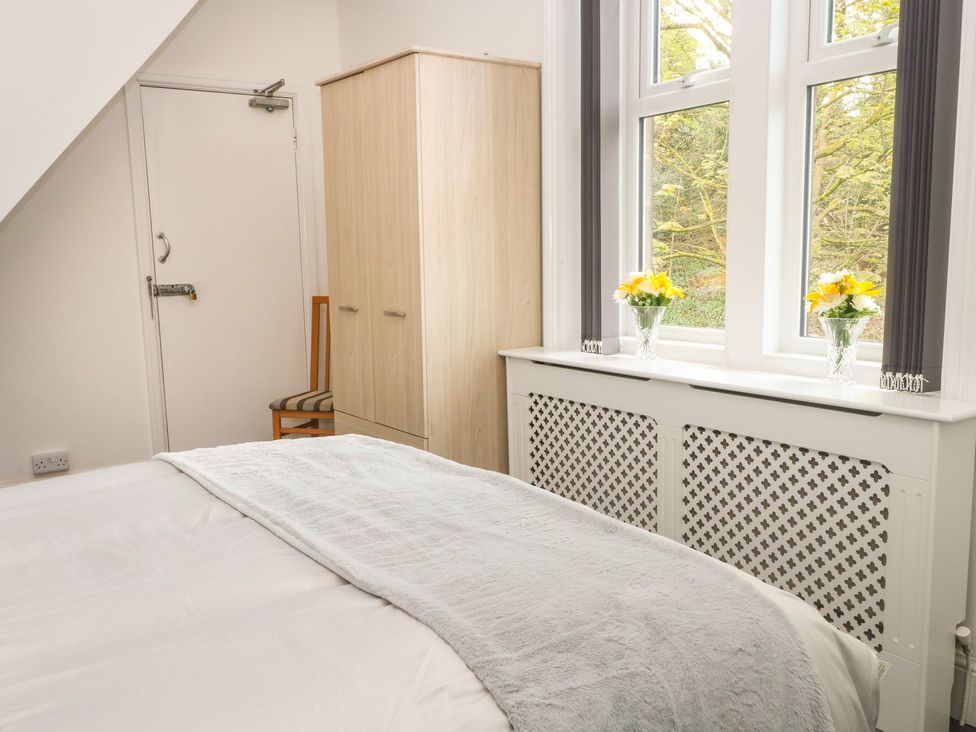 A bedroom with a bed and wardrobe at Beechwood House Hadfield