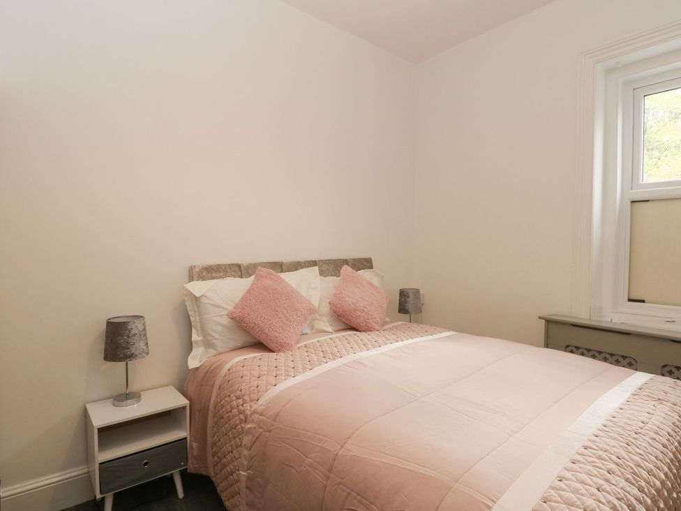 A bedroom with a bed and nightstand at Beechwood House in Hadfield