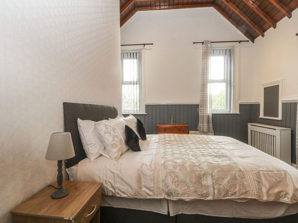 A bedroom with a bed and window at Beechwood House in Hadfield