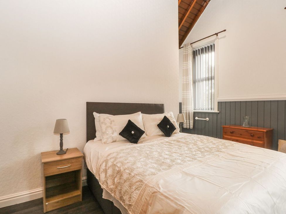 A bedroom with a bed and bedside table at Beechwood House in Hadfield