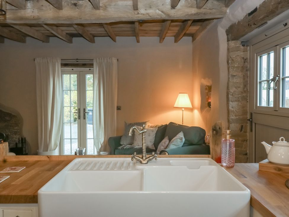 A kitchen with a sink and wooden countertop at The Cow Shed in Ross-on-Wye