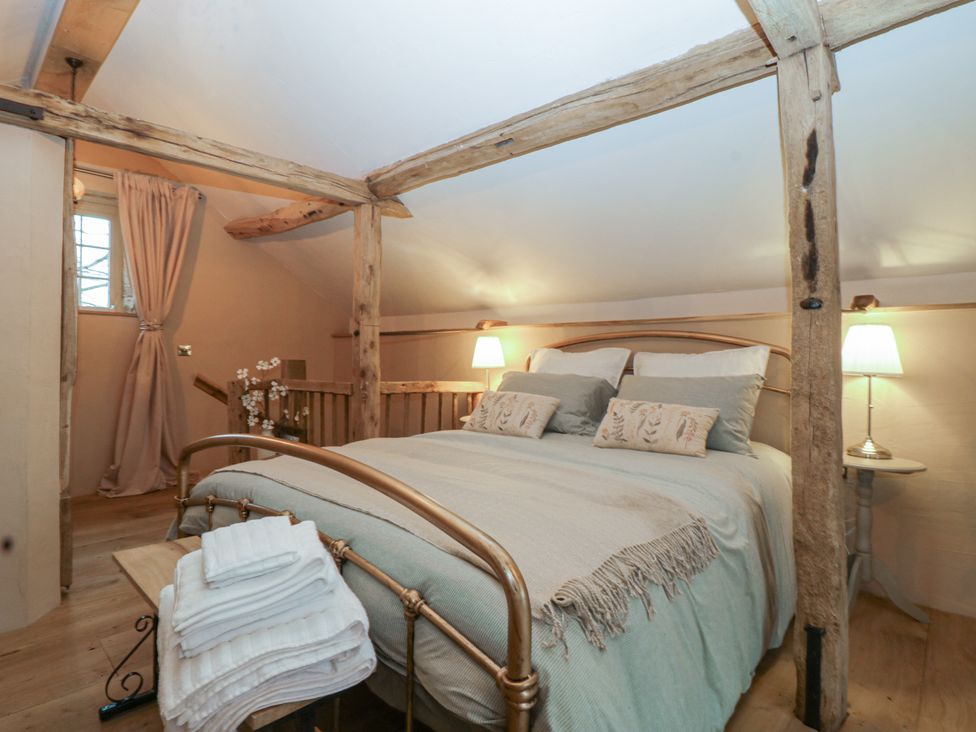 A bedroom with a bed and lamps at The Cow Shed in Ross-on-Wye
