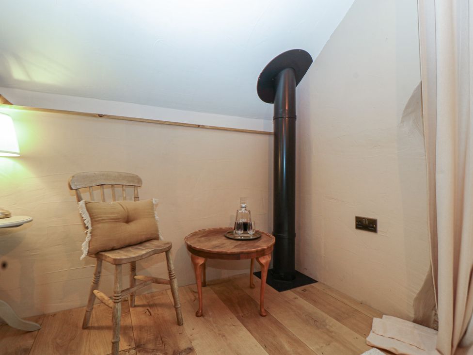 A snug with a chair and table in The Cow Shed Ross-on-Wye