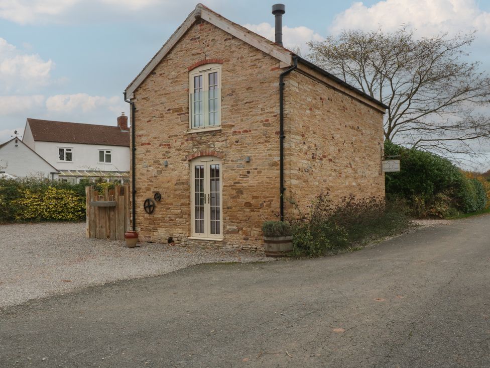 A stone building with windows and a door at The Cow Shed in Ross-on-Wye