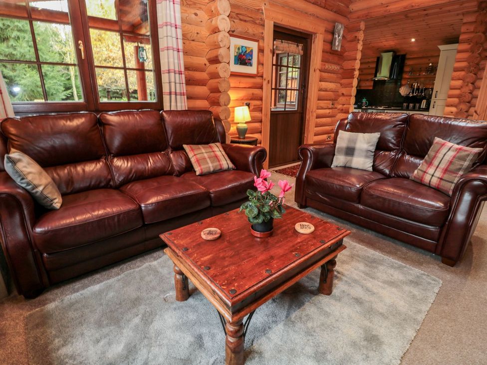 A living room with brown sofas and a wooden coffee table at Little Bears Hideaway @ 23 Lakeside, Felmoor Park near Felton