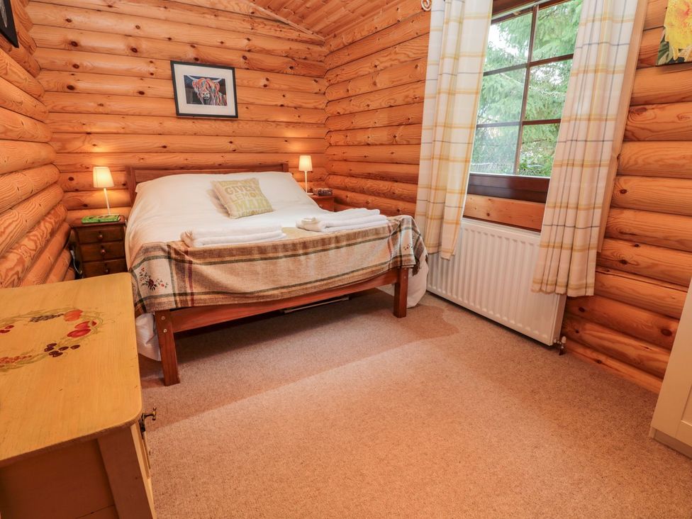 A bedroom with a bed and nightstands at Little Bears Hideaway @ 23 Lakeside Felmoor Park near Felton