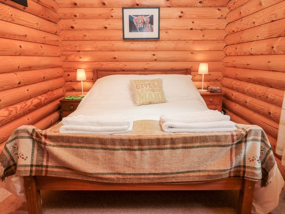 A bedroom with a bed and bedside lamps at Little Bears Hideaway @ 23 Lakeside Felmoor Park near Felton