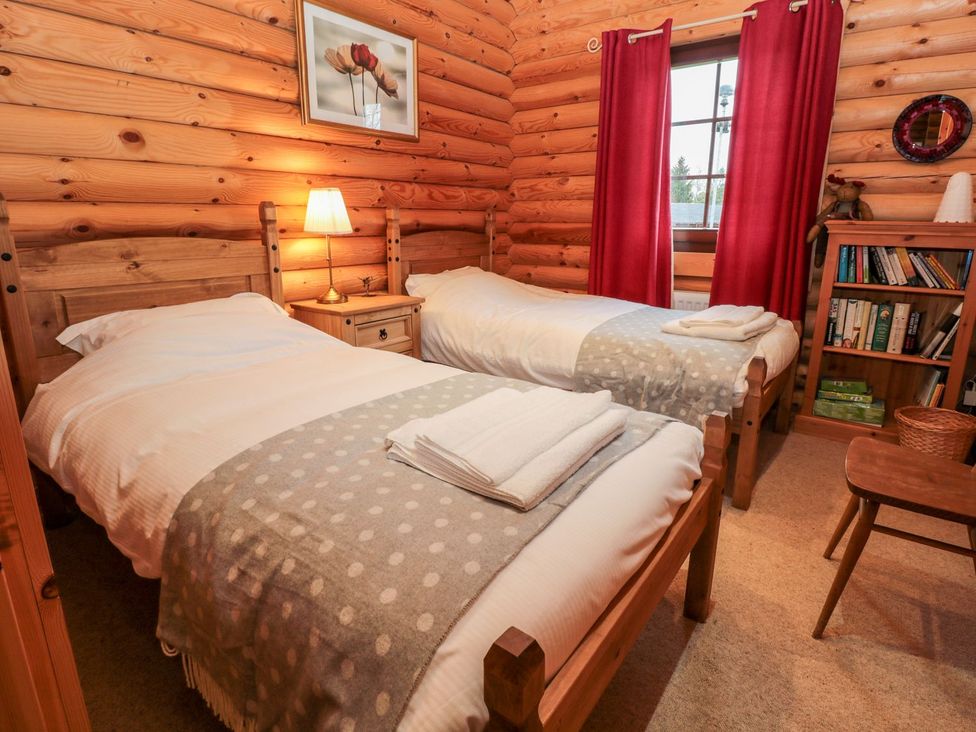 A bedroom with twin beds and a wooden bookshelf at Little Bears Hideaway @ 23 Lakeside Felmoor Park near Felton