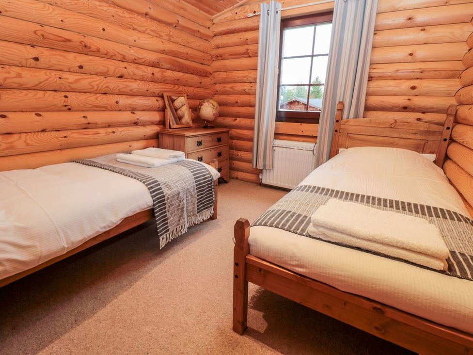 A bedroom with twin beds and a bedside table at Little Bears Hideaway @ 23 Lakeside Felmoor Park near Felton