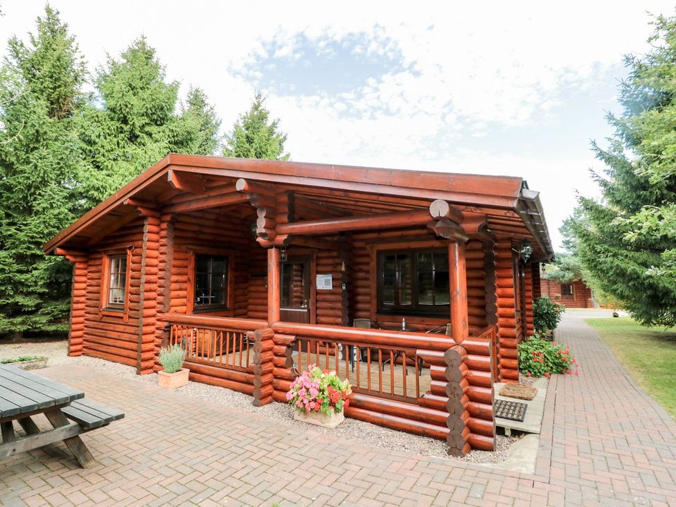 A log cabin exterior with landscaping at Little Bears Hideaway @ 23 Lakeside Felmoor Park near Felton