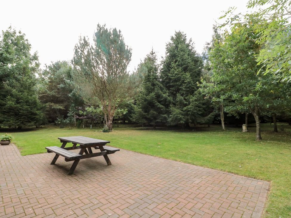 A garden with a table and benches at Little Bears Hideaway @ 23 Lakeside Felmoor Park near Felton