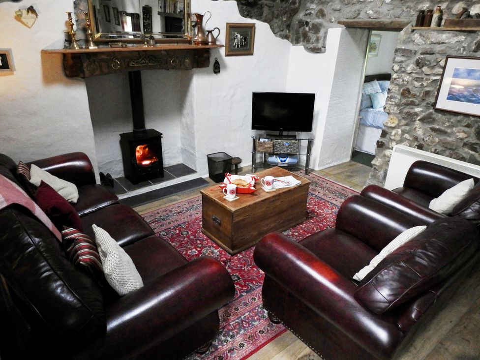 A living room with a fireplace and seating at Butterslade 